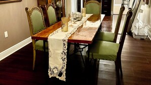 A dining room with a long table, chairs, and a chandelier. - Lovely Furnished Vintage Home (New Orleans)