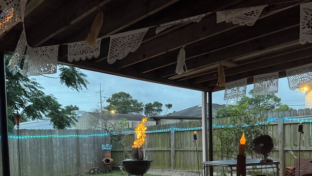 A patio with a table, a candle, and a bottle of wine. - Lovely Furnished Vintage Home (New Orleans)