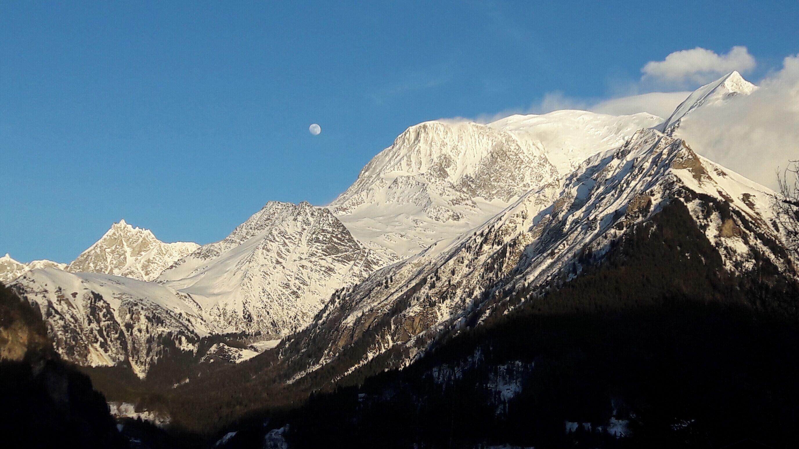 Een berglandschap met besneeuwde toppen en een heldere lucht.
