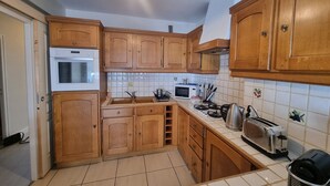 Eine Küche mit Holzausstattung, einer Mikrowelle, einem Toaster und einem Spülbecken.