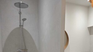 Un bagno con doccia, lavandino e specchio.