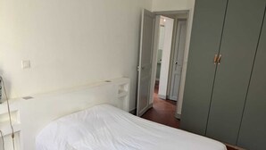 Una camera da letto con un letto, un armadio e una porta che dà su un'altra stanza.