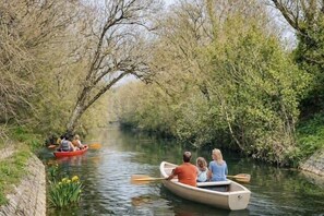 A narrow waterway with boats, surrounded by dense foliage. - Studio with terrace and parking near the Old Port (La Rochelle)