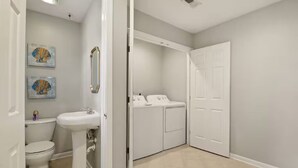 A bathroom with a toilet, sink, and a washing machine. - Furnished 3BR Corporate Rental in Petersburg (Petersburg)