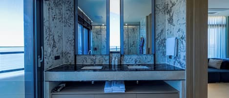 A modern bathroom with a large mirror, two sinks, and a bathtub.