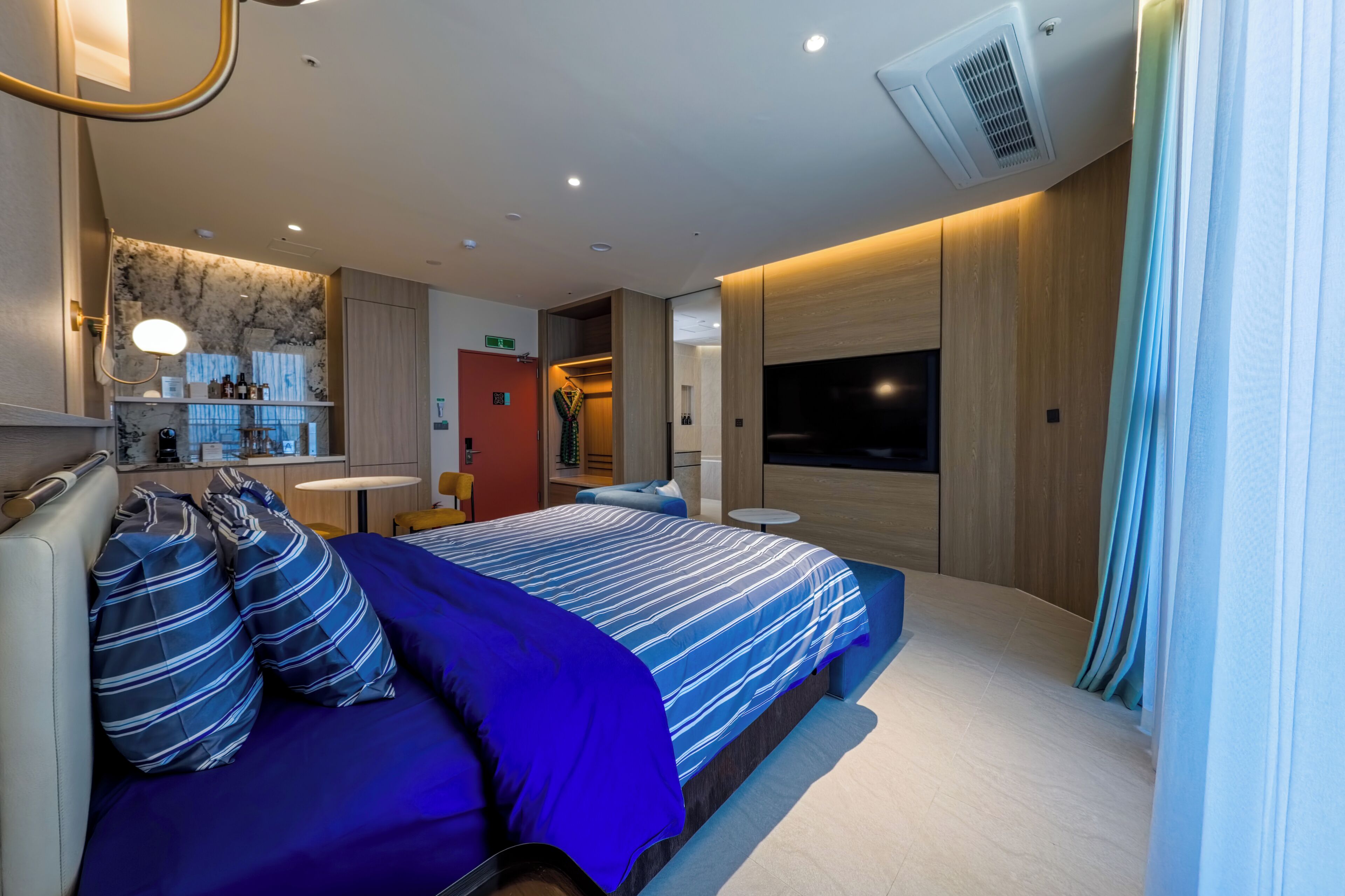 Une chambre à coucher moderne avec un lit, une table de chevet et un téléviseur.