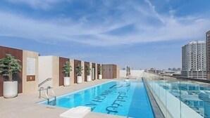 A rooftop pool with a clear view of the city skyline. - Vogue | Binghatti Galaxy JVC near Circle Mall (Dubai)