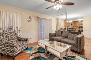 A living room with a sofa, armchair, coffee table, and a ceiling fan. - MidTerm Housing  Utilities Included Move-In Ready (Prince George)