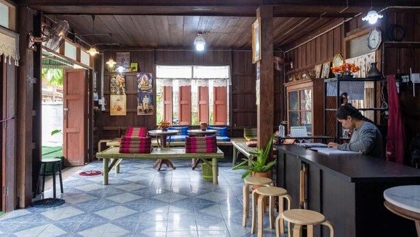 Un restaurante con interior de madera, suelo de baldosas y una barra con taburetes.