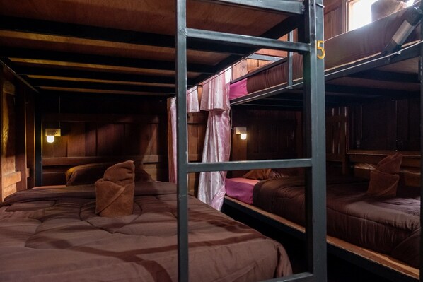 A bunk bed room with wooden walls and a metal bunk bed structure. - Baan Pai Hostel (Pai)
