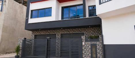 Un moderno edificio de dos pisos con techo plano, ventanas amplias y fachada de piedra.