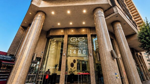 A building entrance with large columns, a glass door, and a sign reading 'Gran Santiago Edificio Huuerfanos 1400'. - Spacious apt. 2 bedr. Fully equipped downtown Stgo. (Santiago)