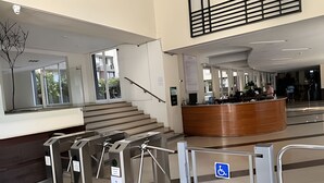 A modern lobby with a reception desk, a staircase, and a handicap-accessible sign. - Spacious apt. 2 bedr. Fully equipped downtown Stgo. (Santiago)