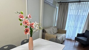 A modern living room with a dining table, chairs, a sofa, and a large window with curtains. - Spacious apt. 2 bedr. Fully equipped downtown Stgo. (Santiago)