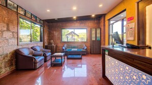 A reception area with a reception desk, a sofa, two armchairs, and a coffee table.