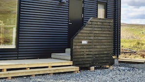 A small, single-story building with a metal roof and a dark blue exterior. - Northern Lights Cabin - Syðribrú (Selfoss)