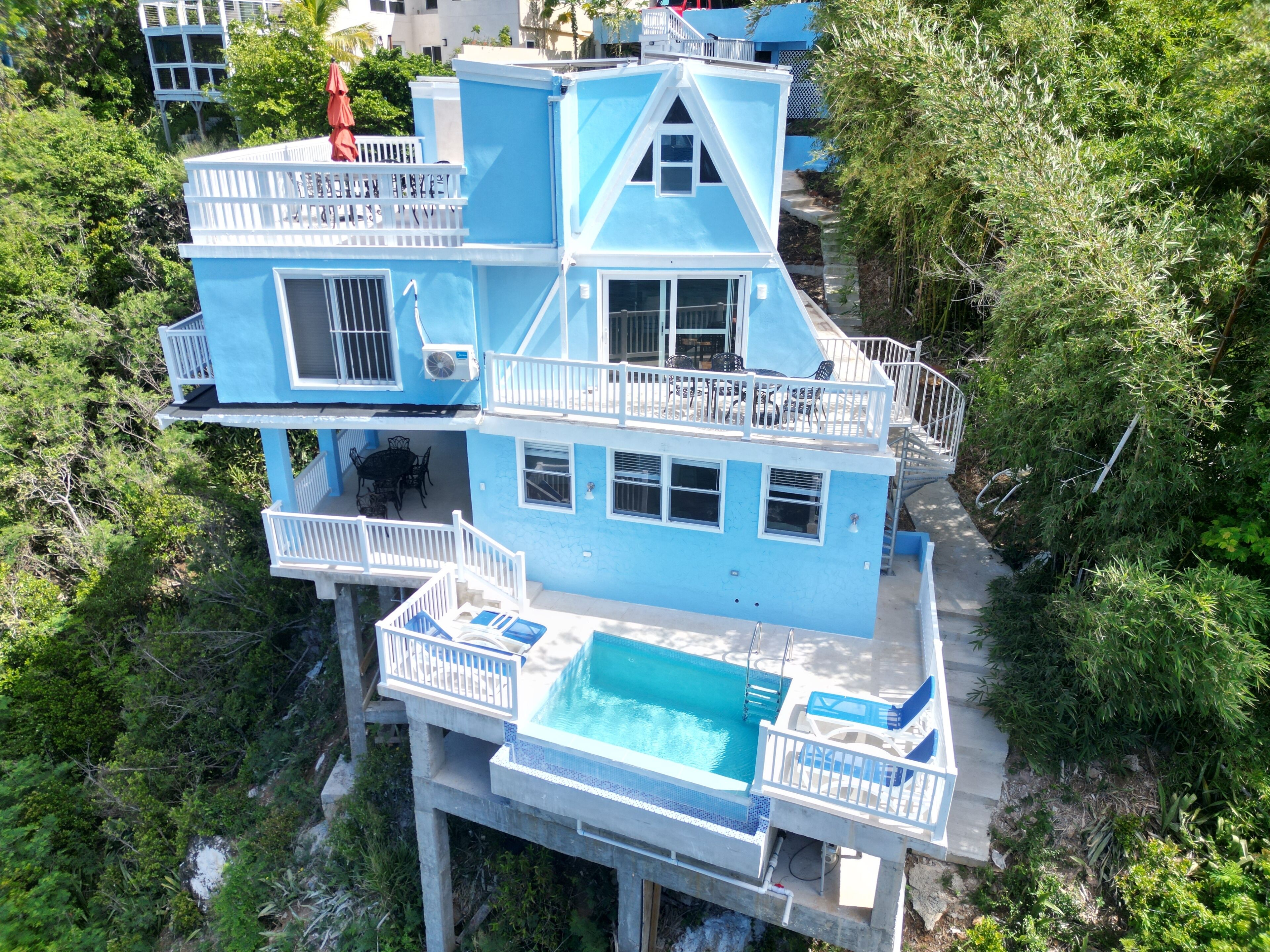 Un edificio de varios pisos con piscina, balcones y mobiliario de exterior.