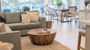 Ein modernes Wohnzimmer mit Sofa, Couchtisch und Essbereich.