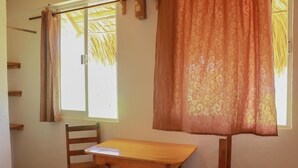 A room with a wooden table and chairs, a window with curtains, and a shelf. - Casa Acalli Ocean View (San Pedro Pochutla)