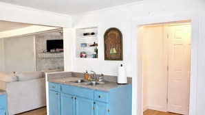 A kitchen with blue cabinets, a sink, and a decorative wall piece. - Cozy Steinhatchee Getaway, Beachy + River Close (Steinhatchee)
