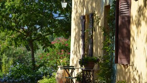 A building with a window, a door, and a hanging light fixture. - Near Cannes, authentic Bastide set in a garden planted with century-old olive trees (mouans sartoux)