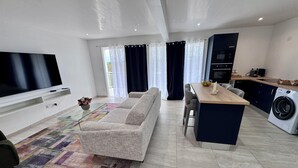 Una sala de estar moderna con televisor de pantalla plana, sofá, mesa de centro y alfombra.