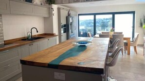 Una cocina moderna con una isla central, armarios empotrados y un amplio ventanal con vistas al exterior.