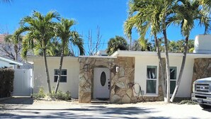 Una casa con fachada de piedra, una puerta blanca y un garaje.