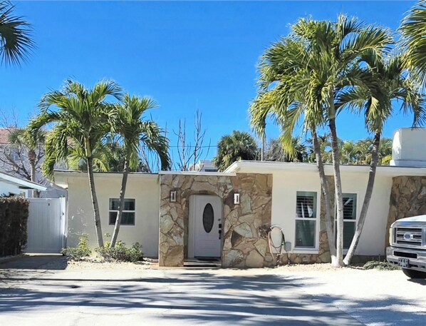 Ein Haus mit einer Steinauffahrt, einer weißen Tür und einer Garage.