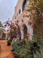 Un edificio con ventanas de arco y una escalera que lleva a una entrada.