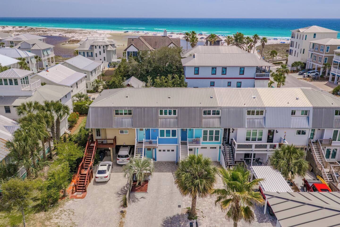 A coastal residential area with multiple houses, a beach, and a clear view of the ocean.