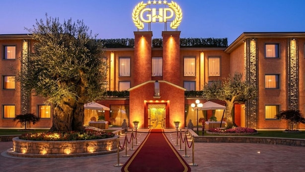 A hotel entrance with a red carpet, a sign with 'GHP' and stars, and a well-lit facade. - Grand Hotel del Parco (Stezzano)