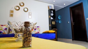 A room with a bed, a table with a glass bottle, and a wall with decorative items. - Chic Designer Apartment with Pool Access (Agadir)