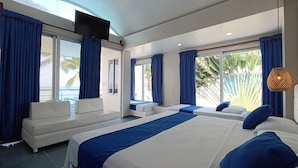 A modern hotel room with a large bed, a sofa, a TV, and large windows with curtains. - Hotel Portoalegre (Coveñas)