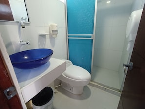 A bathroom with a blue basin, white toilet, and a shower area. - Hotel Portoalegre (CoveƱas)