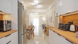 A modern kitchen with stainless steel appliances, wooden countertops, and a marble floor. - Athenian Glow Fully Renovated Apartment (Athina)