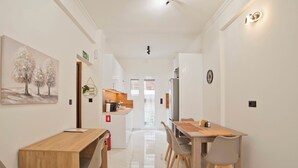 A modern kitchen with white cabinets, a wooden countertop, and a built-in oven. - Athenian Glow Fully Renovated Apartment (Athina)