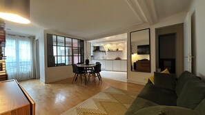Um apartamento moderno com área de jantar, cozinha e sala de estar.
