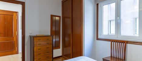 Tabla de planchar con plancha y ropa de cama