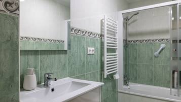 Ein Badezimmer mit Waschbecken, Spiegel, Dusche und Handtuchhalter.
