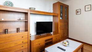 Un meuble de rangement en bois comprenant un téléviseur à écran plat, des tiroirs et un placard.