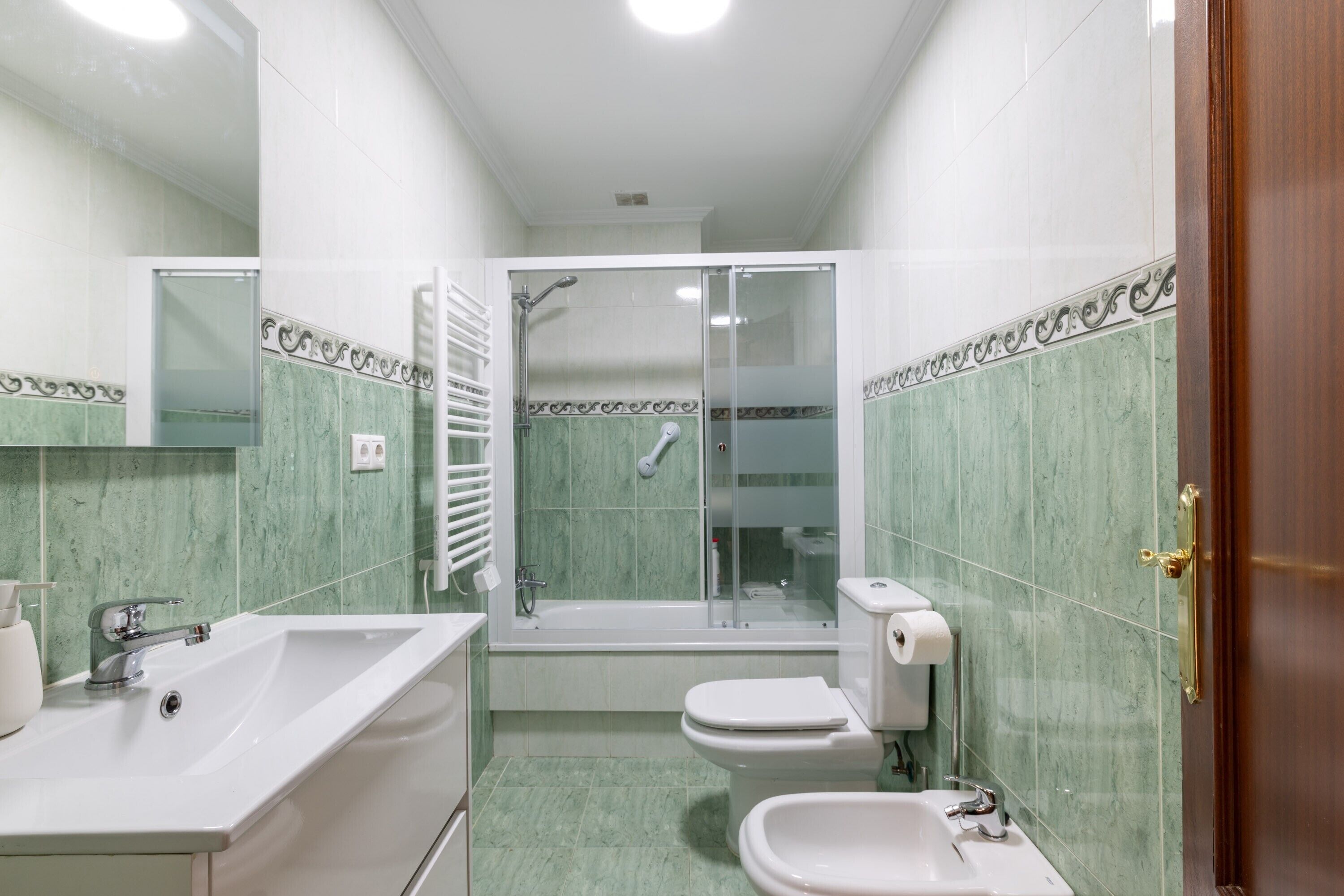 Une salle de bain équipée d’un lavabo, de toilettes, d’un bidet et d’une douche.