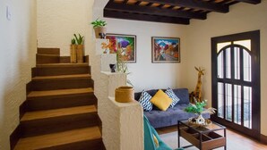 A staircase leading to a living area with a sofa, a giraffe decoration, and two framed artworks. -  Casa Cami Anturi (Antigua Guatemala)