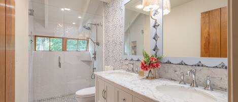 A bathroom with a shower, toilet, and vanity with a mirror and sink.