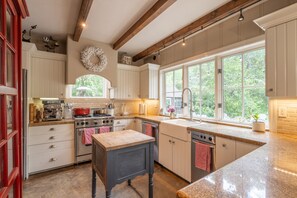 A kitchen with wooden beams, a large window, and a coffee station. - Private River Access & Walk to Village! (Carmel Valley)