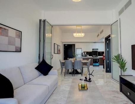 A modern living room with a sofa, coffee table, and dining area.
