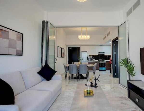 Een moderne woonkamer met een bank, salontafel en een eethoek.