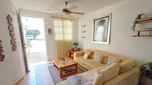 Un salon avec un canapé, une table basse et un ventilateur de plafond.