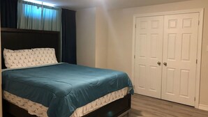 Un dormitorio con cama, armario y puerta.