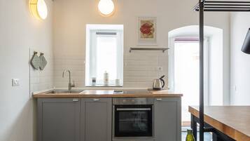 Una cucina moderna con mobili grigi, un lavello, un forno e una finestra.